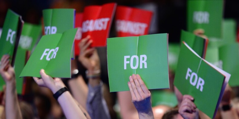 Members holding Congress voting cards in the air