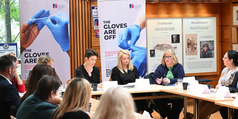 RCN members speak to the Scottish Minister for Community Care, with The Gloves are Off banners in the background