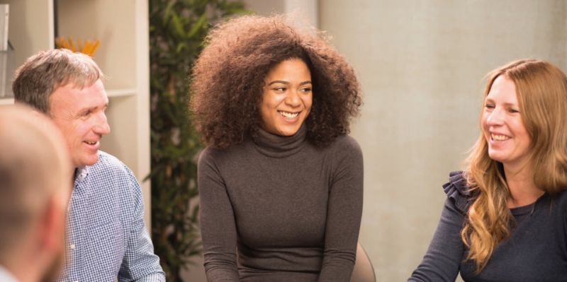A group of people sat in a circle  with discussion taking place.