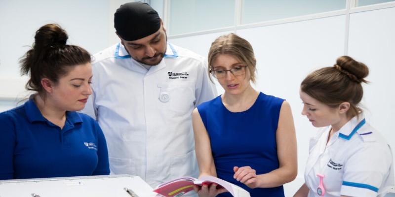 Three students learning during nursing training with female instructor