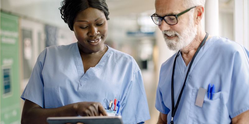 Woman and man in a hospital looking at a tablet