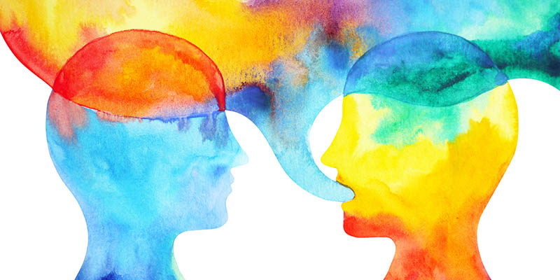 Two colourful heads talking with a speech bubble above mixing their colours