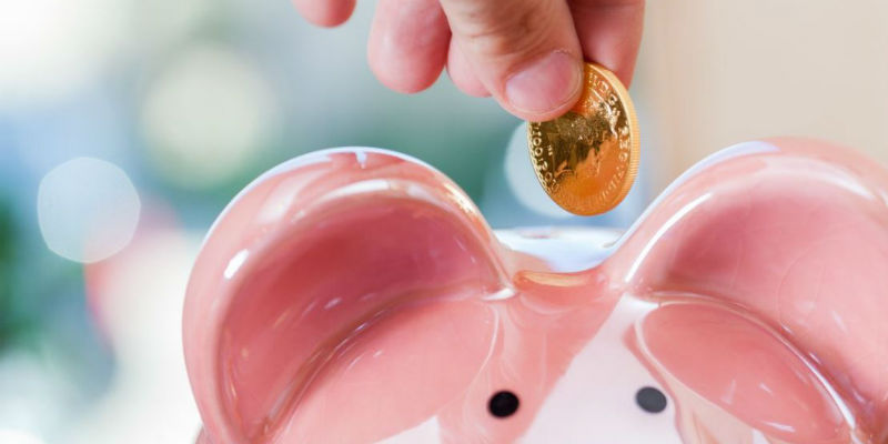 Piggy bank with someone putting a coin into it