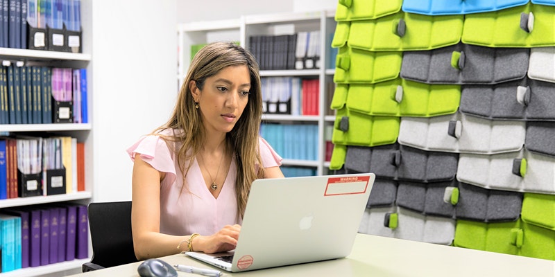 Two people sitting at a computer and smiling