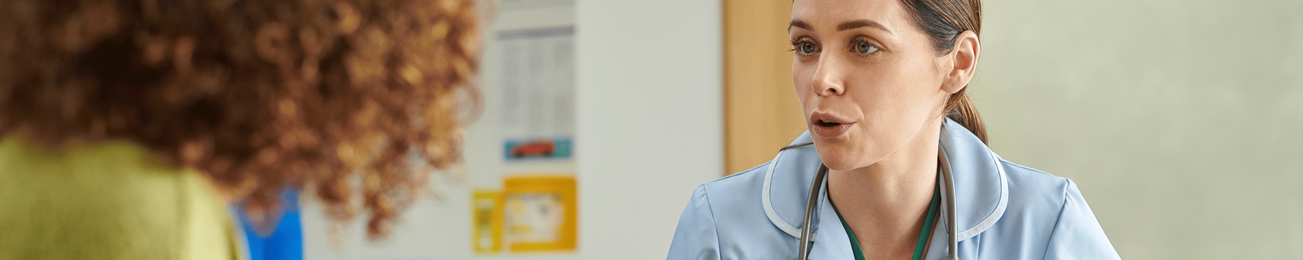 A nurse speaking to a patient in a GP office
