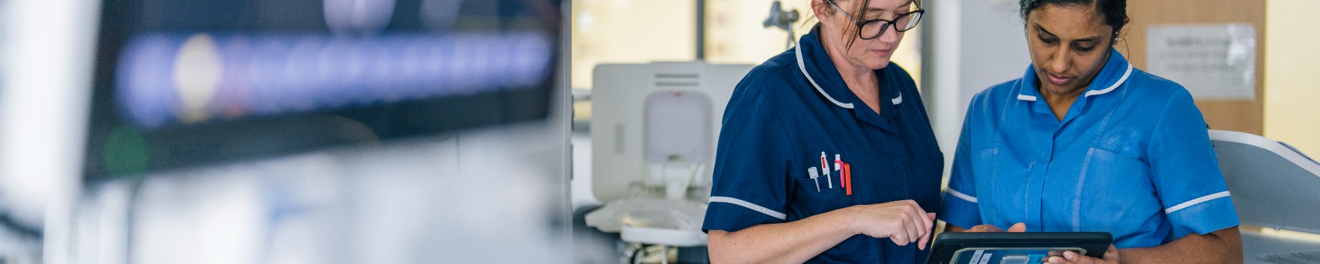 Nurse and Senior Nurse looking at an electronic tablet together