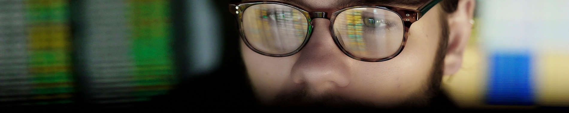 computer screen reflected in man's glasses
