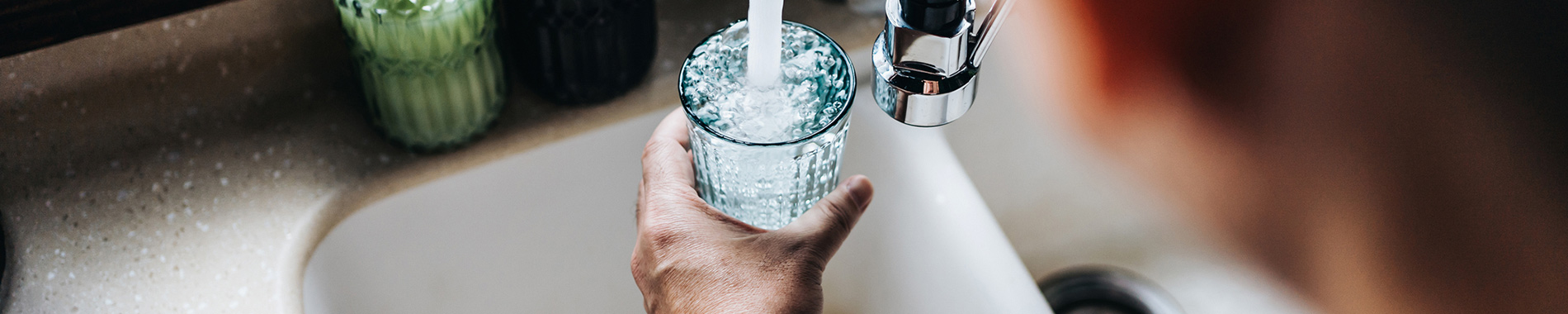 man filling up glass of water