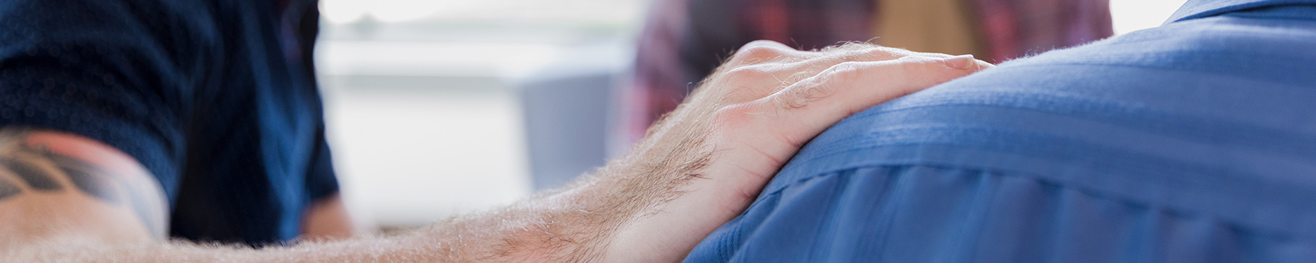 man putting his hand on another man's shoulder