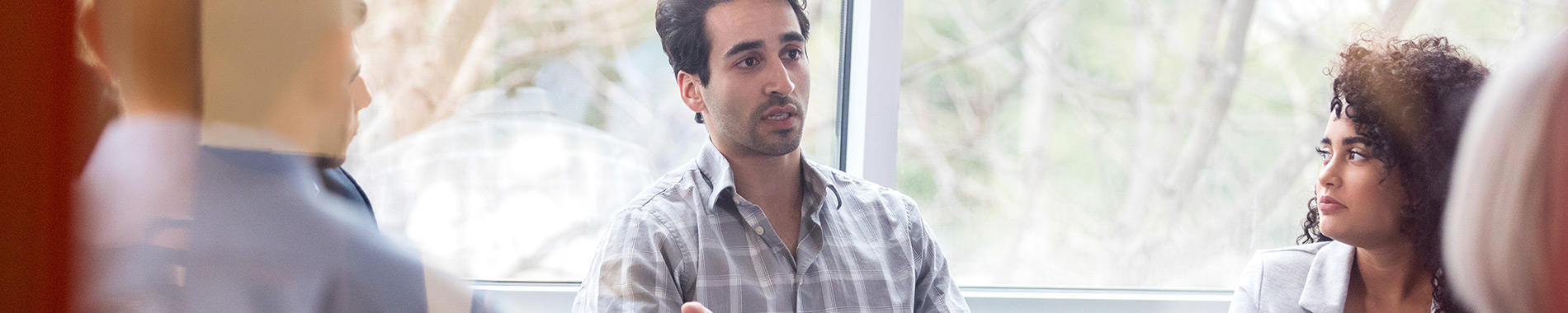 man sitting and talking to a group of people