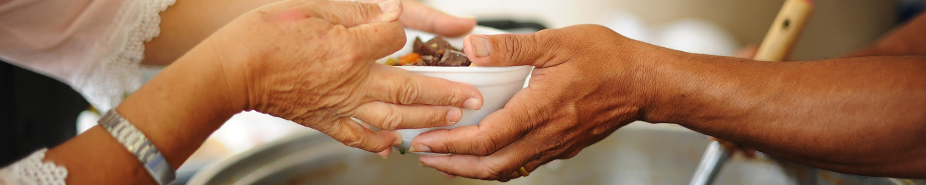 close-up of woman handing someone bowl of food