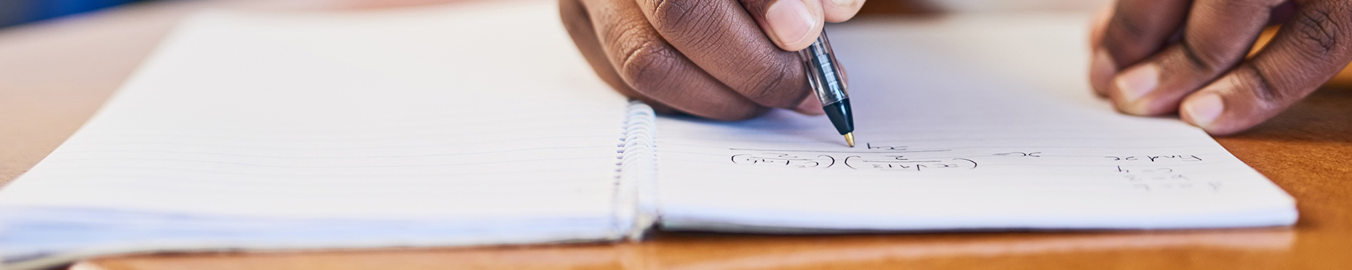 close-up of person writing in notepad