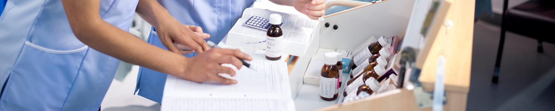 two nurses at a desk with medication