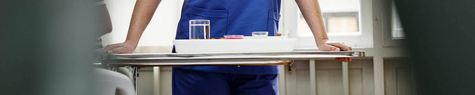 nurse standing behind tray