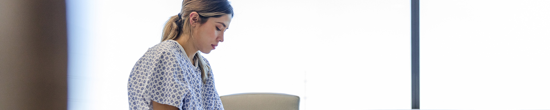 woman in hospital gown looking pensive