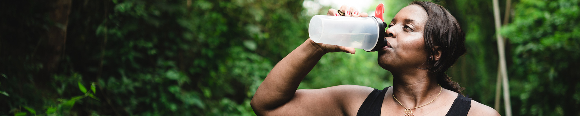 woman drinking water outdoors