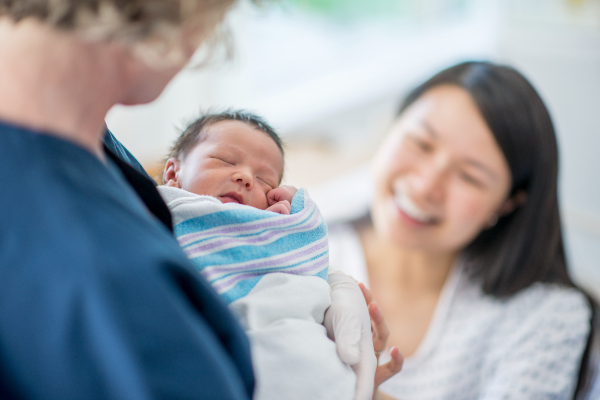 Mother and nurse looking at baby