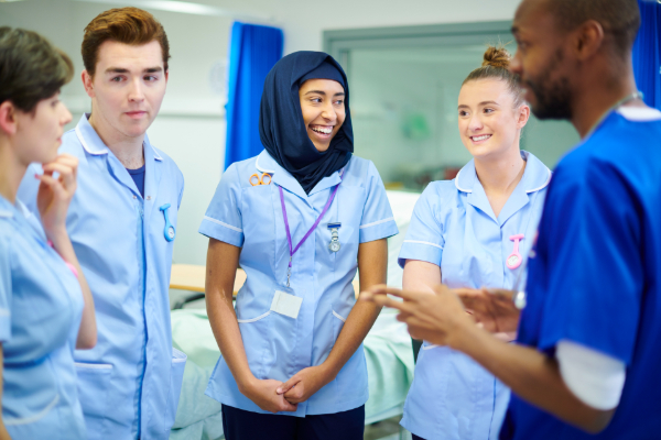 Three students talking with their mentor