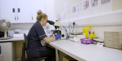 Nurse looking in microscope