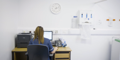 Nurse sitting at a desk on a computer
