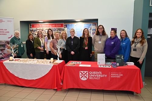 Students standing by a conference stand