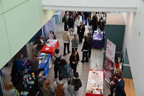 Students walking down a corridor with conference stands