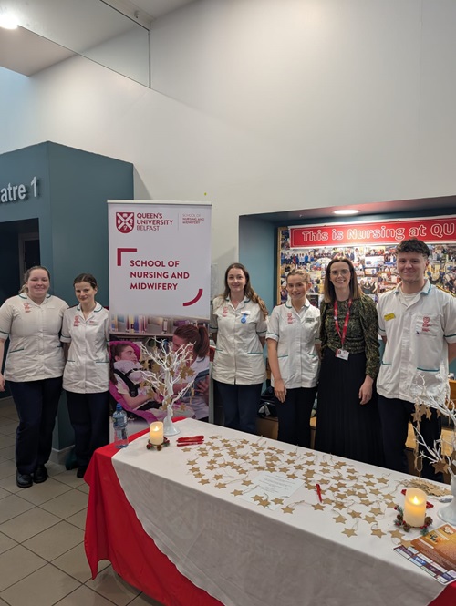 Nursing staff standing by a conference stand