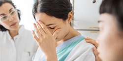 Woman being comforted by two female colleagues 