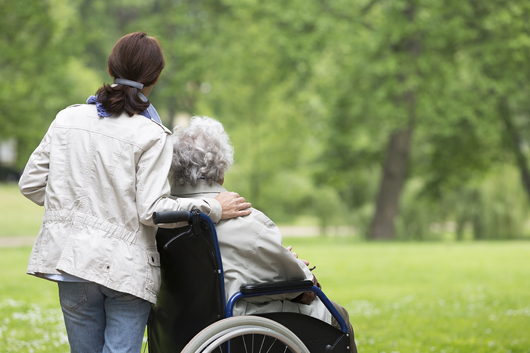 Woman standing next to another woman in a wheelchair