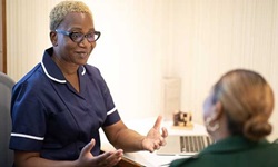 A nurse talking to a patient in a GP office