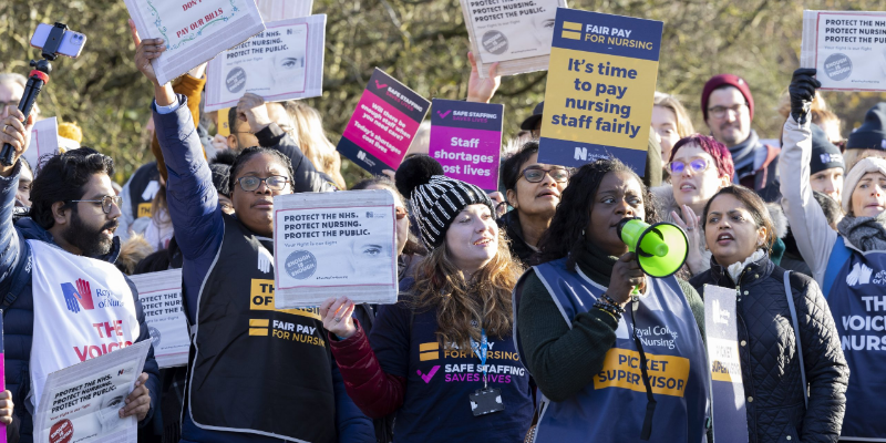A group of activists holding placards at a picket line.