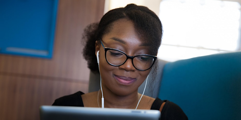 A woman sits at a laptop