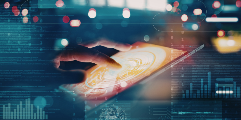 A hand interacts with a glowing tablet displaying a bright circle on a digital interface. Background and foreground show abstract data and graphs, conveying a futuristic and tech-focussed atmosphere.