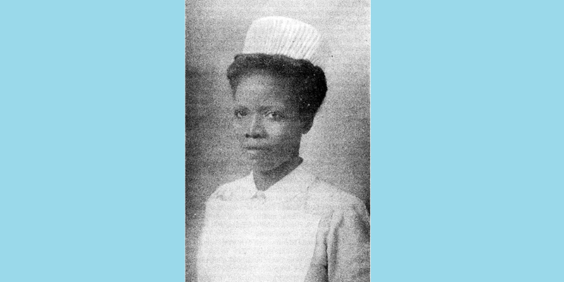 Light blue background with a 1940s, greyscale image set on top. The image shows black, Nigerian nurse Koforowola Abeni Pratt at Nightingale School for Nurses, St. Thomas' Hospital, London. She is looking at the camera and wearing a light-coloured nurses uniform including dress, apron and cap.