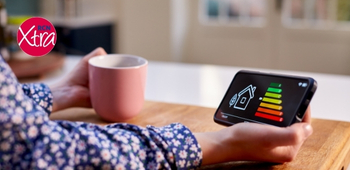 close-up of a woman's hand holding a phone, with an energy efficiency chart on the screen. there is an rcn xtra logo in the top left-hand corner