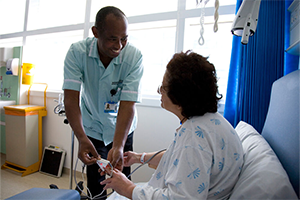 A nurse helping a patient in bed