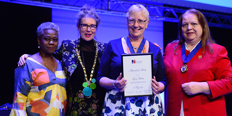Cumbria Branch's Karen Dutton receiving her RCN Award of Merit at RCN Congress 2019, flanked by Chief Executive and General Secretary Dame Donna Kinnair, RCN President Professor Anne Marie Rafferty, and Chair of RCN Council Sue Warner Cumbria Branch's Karen Dutton receiving her RCN Award of Merit at RCN Congress 2019, flanked by Chief Executive and General Secretary Dame Donna Kinnair, RCN President Professor Anne Marie Rafferty, and Chair of RCN Council Sue Warner