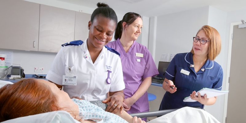 A student nurse and nursing staff assess a patient