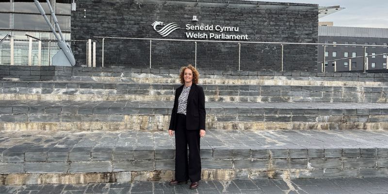 Nia Boughton stands on steps outside Welsh Parliament building