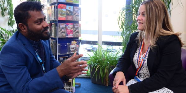 Cultural ambassador Suresh Packiam chatting to a colleague in an office setting