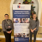 Leanne Hume and Michelle Raddings standing beside a poster with the title 'Independent Health and Social Care (IHSC)'