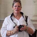 Leonore Newson in a white shirt holding a camera 145x145