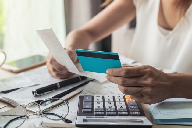 Woman checking bills with calculator