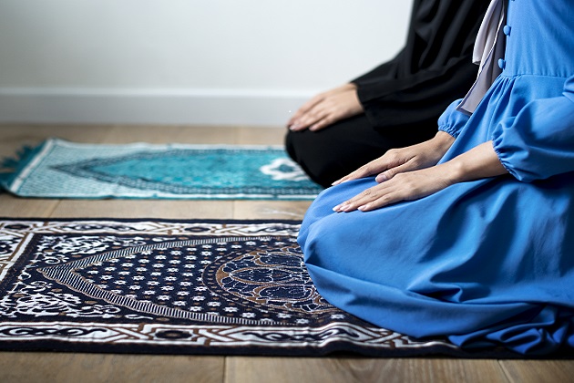 People's knees on a prayer mat
