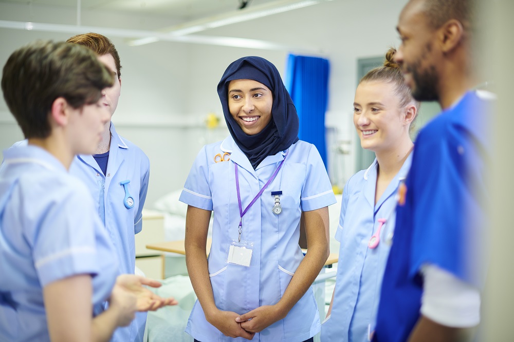 nurses in a group talking and smiling