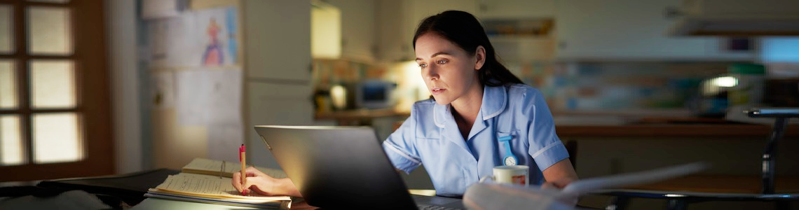 Female nurse at laptop working from home