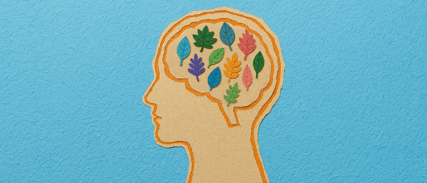 A scrapbook-style illustration of a human head in profile, with the brain area filled with small leaves made from paper, in a variety of bright colours and shapes..