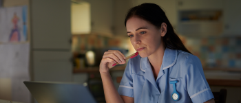 financial wellbeing female nursing writing at desk