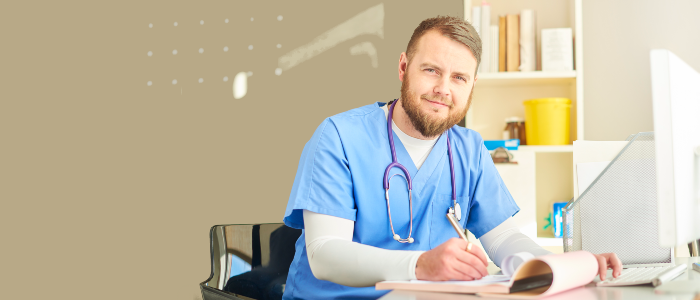 male nursing writing at desk