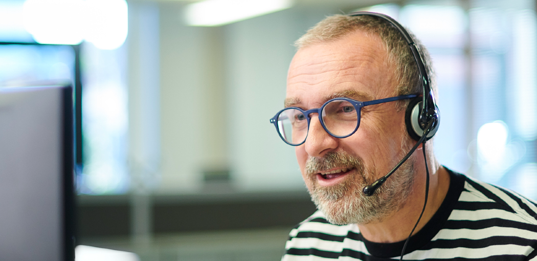 Male advisor on telephone Male advisor in an office talking using a telephone headset